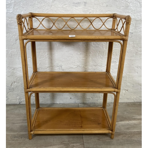 63 - A cane and wicker three tier bookshelf - approx. 90cm high x 66cm wide x 32cm deep