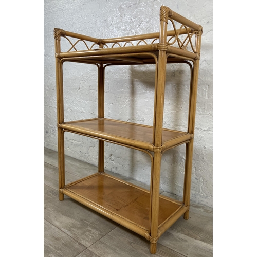 63 - A cane and wicker three tier bookshelf - approx. 90cm high x 66cm wide x 32cm deep