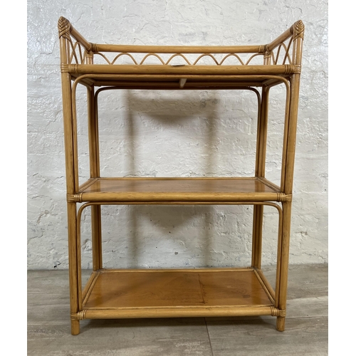 63 - A cane and wicker three tier bookshelf - approx. 90cm high x 66cm wide x 32cm deep