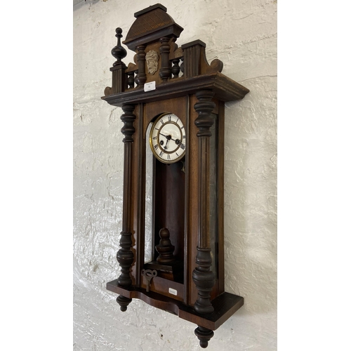 71 - A Victorian mahogany cased Vienna wall clock with pendulum and key