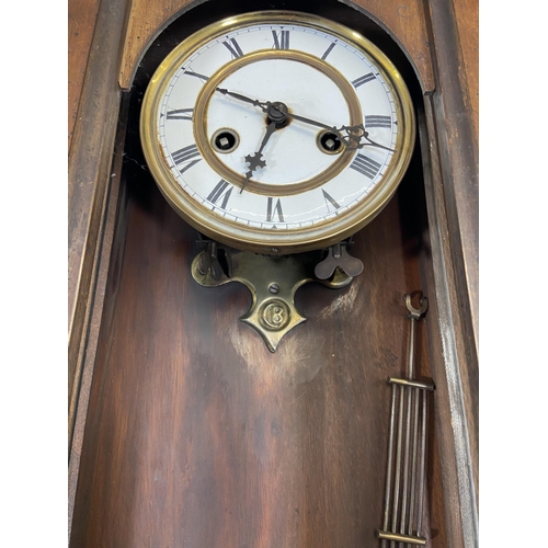 71 - A Victorian mahogany cased Vienna wall clock with pendulum and key