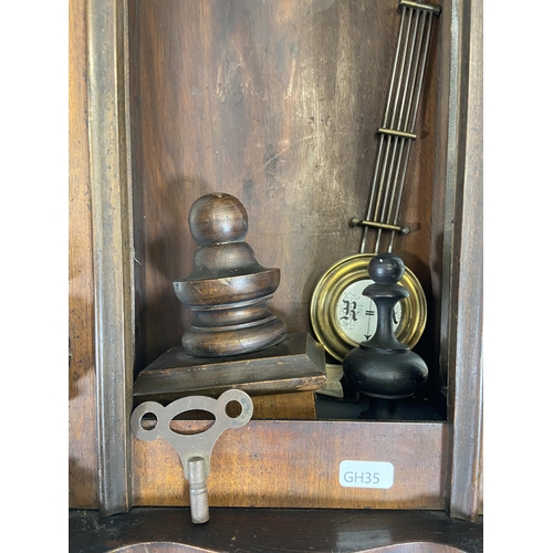 71 - A Victorian mahogany cased Vienna wall clock with pendulum and key