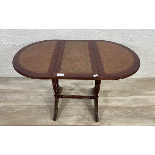 74 - Three pieces of reproduction mahogany and leather furniture, one drop leaf side table, one nest of t... 