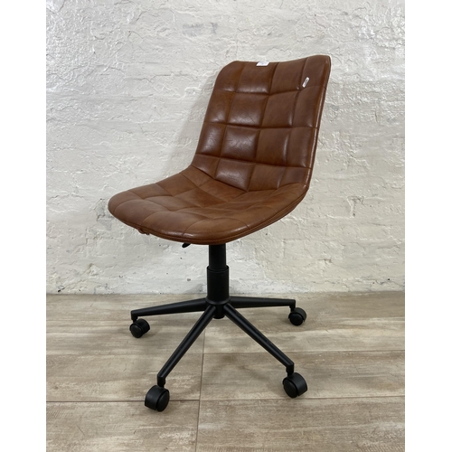 77 - A modern tan vinyl and black metal swivel office desk chair