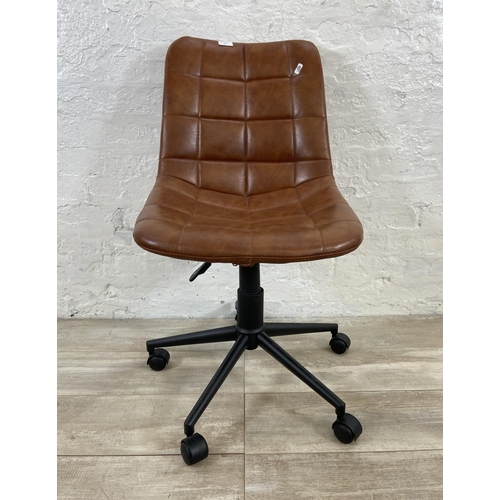 77 - A modern tan vinyl and black metal swivel office desk chair