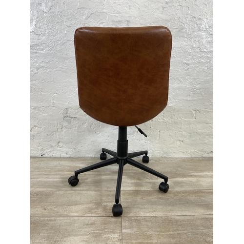 77 - A modern tan vinyl and black metal swivel office desk chair