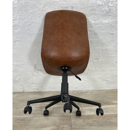 77 - A modern tan vinyl and black metal swivel office desk chair