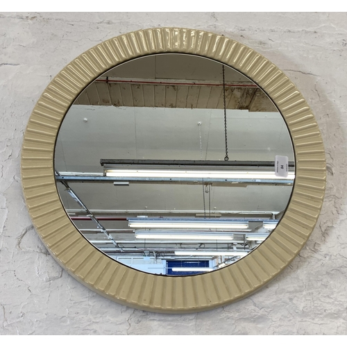 84 - A mid 20th century plastic framed circular wall mirror - approx. 49cm diameter