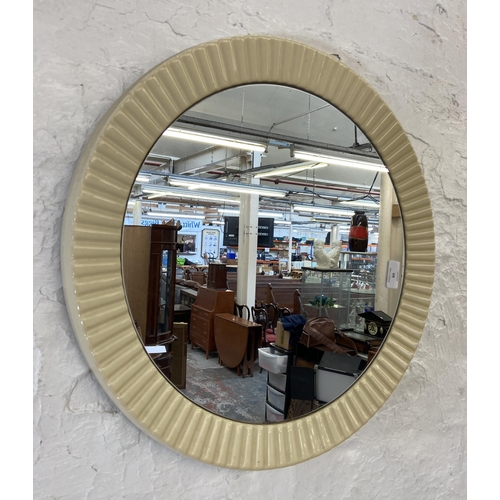 84 - A mid 20th century plastic framed circular wall mirror - approx. 49cm diameter