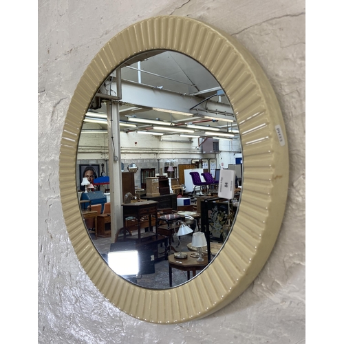 84 - A mid 20th century plastic framed circular wall mirror - approx. 49cm diameter