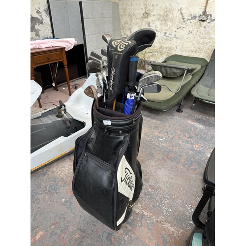 1027 - A Titleist golf bag containing Mizuno MX-23 iron set, two Cleveland launcher woods, Cleveland Hi Bor... 