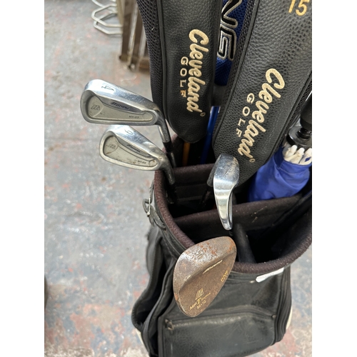 1027 - A Titleist golf bag containing Mizuno MX-23 iron set, two Cleveland launcher woods, Cleveland Hi Bor... 