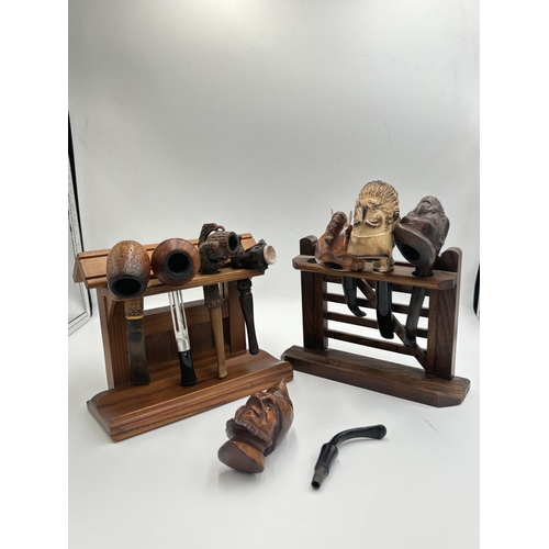 2265 - Two wooden pipe stands containing eight vintage smoking pipes to include carved meerschaum head, car... 