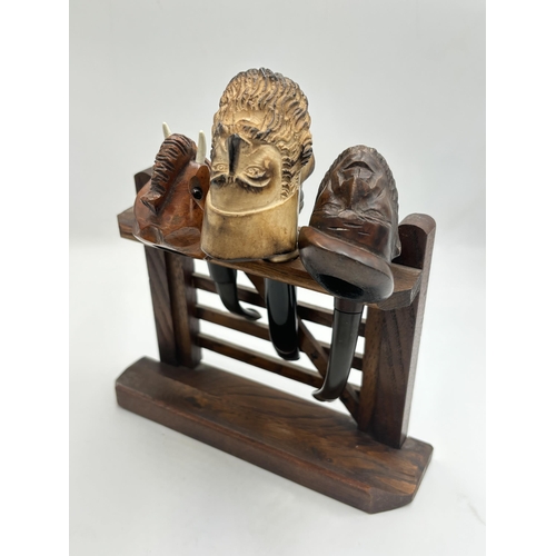 2265 - Two wooden pipe stands containing eight vintage smoking pipes to include carved meerschaum head, car... 