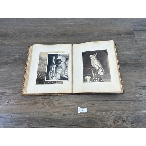 519 - An early 20th century photograph album containing a collection of black and white photographs and cu... 