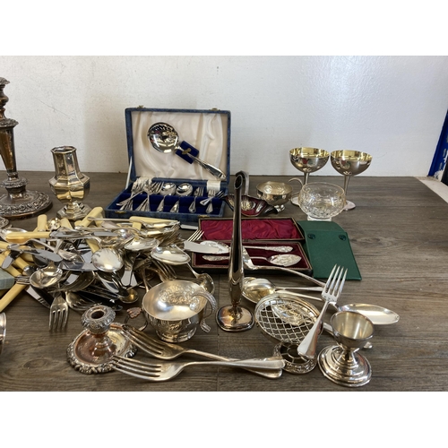 419 - A collection of antique and later metalware to include cutlery, candlesticks, sugar shaker etc.