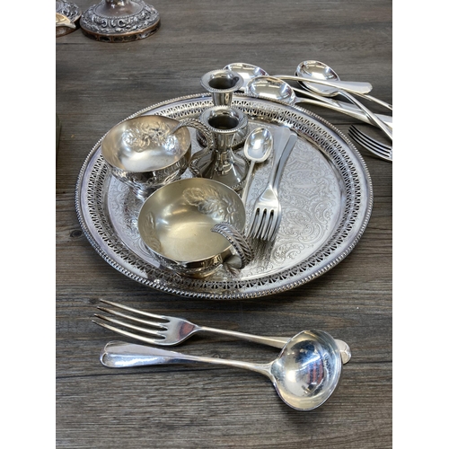 419 - A collection of antique and later metalware to include cutlery, candlesticks, sugar shaker etc.