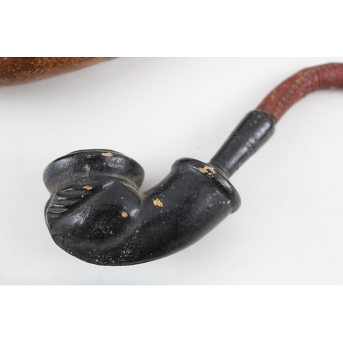 2267 - Three antique smoking pipes to include grotesque clay gargoyle, 18th century petrified wood etc.