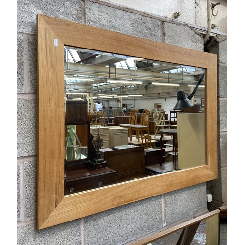 246 - A modern oak framed over mantel bevelled edge wall mirror - approx. 78cm high x 108cm wide