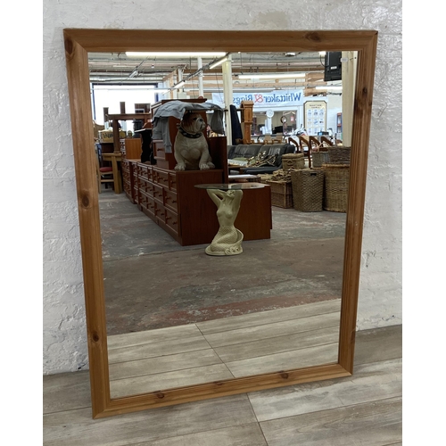 279 - A modern pine framed overmantel wall mirror - approx. 100cm high x 132cm wide