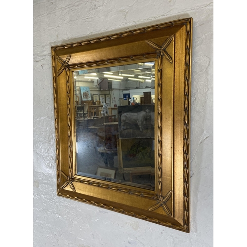 280 - A modern gilt framed bevelled edge wall mirror - approx. 89cm high x 80cm wide