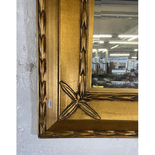 280 - A modern gilt framed bevelled edge wall mirror - approx. 89cm high x 80cm wide