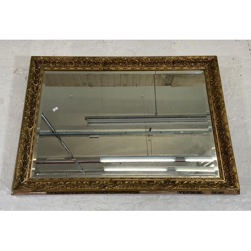 284 - A gilt framed bevelled edge overmantel wall mirror - approx. 74cm high x 100cm wide