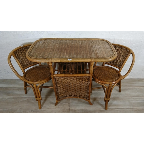 100 - A mid 20th century wicker and cane three piece dining suite comprising table and two chairs - table ... 