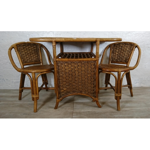 100 - A mid 20th century wicker and cane three piece dining suite comprising table and two chairs - table ... 