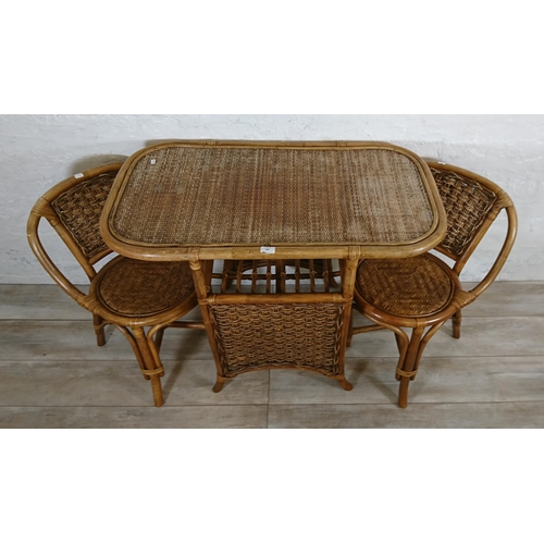 100 - A mid 20th century wicker and cane three piece dining suite comprising table and two chairs - table ... 