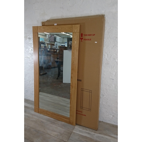 107 - A boxed JB Global oak framed wall mirror - approx. 150cm x 80cm