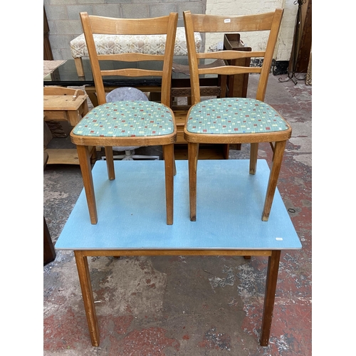 117 - A 1950s blue laminate and beech rectangular kitchen table and two chairs - table approx. 76cm high x... 