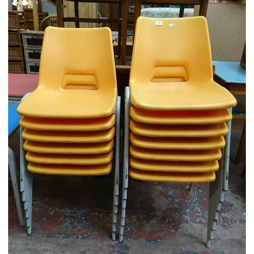 123 - Thirteen mid/late 20th century yellow plastic and tubular metal stacking children’s school chairs