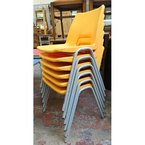 123 - Thirteen mid/late 20th century yellow plastic and tubular metal stacking children’s school chairs