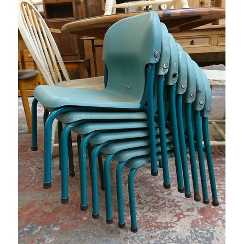 124 - Twenty one mid/late 20th century green plastic and tubular metal stacking children's school chairs