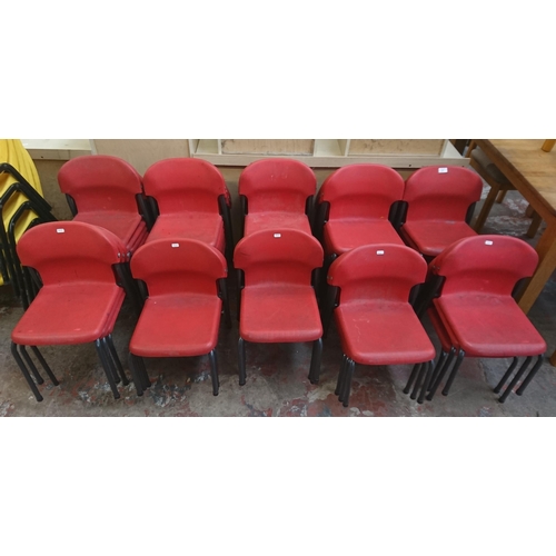 125 - Forty three mid/late 20th century red plastic and tubular metal stacking children's school chairs