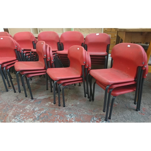 125 - Forty three mid/late 20th century red plastic and tubular metal stacking children's school chairs