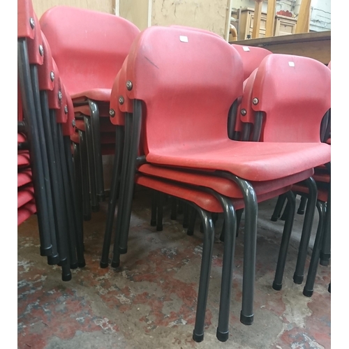 125 - Forty three mid/late 20th century red plastic and tubular metal stacking children's school chairs