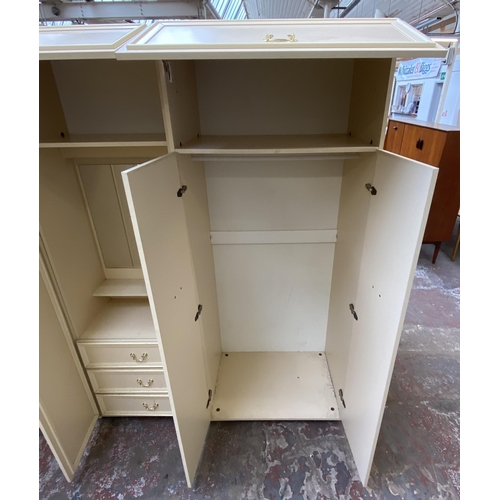 130 - A 1980s white laminate triple wardrobe - approx. 182cm high x 210cm wide x 55cm deep