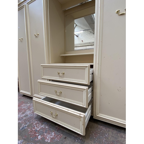 130 - A 1980s white laminate triple wardrobe - approx. 182cm high x 210cm wide x 55cm deep