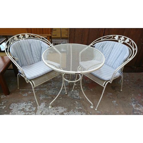 134 - A modern white metal three piece patio set comprising circular table and two armchairs - table appro... 