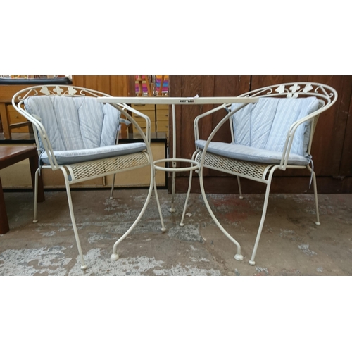 134 - A modern white metal three piece patio set comprising circular table and two armchairs - table appro... 