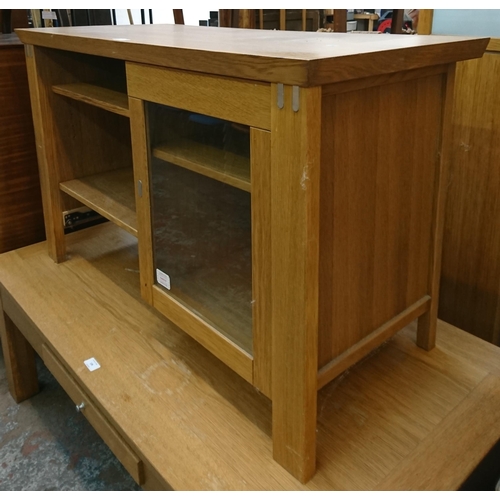 138 - A modern oak TV stand - approx. 65cm high x 106cm wide x 47cm deep