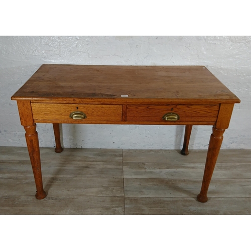 147 - A mid 20th century oak two drawer writing desk - approx. 76cm high x 121cm wide x 64cm deep