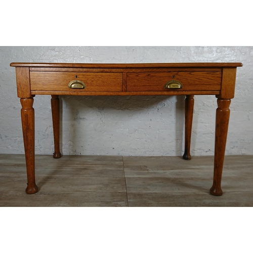 147 - A mid 20th century oak two drawer writing desk - approx. 76cm high x 121cm wide x 64cm deep