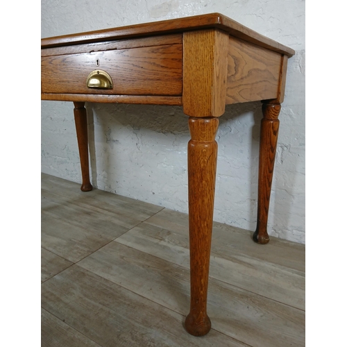 147 - A mid 20th century oak two drawer writing desk - approx. 76cm high x 121cm wide x 64cm deep