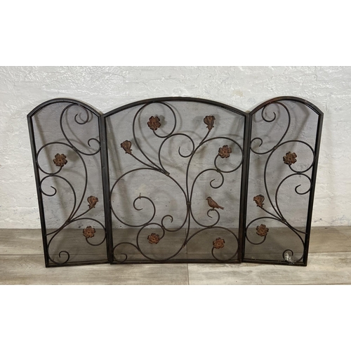 16 - An Art Nouveau style black metal and meshed floral design three section folding fire screen - approx... 