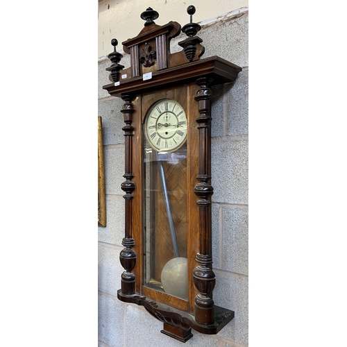 24 - A Victorian carved walnut and mahogany cased Vienna wall clock with pendulum and weight - approx. 11... 