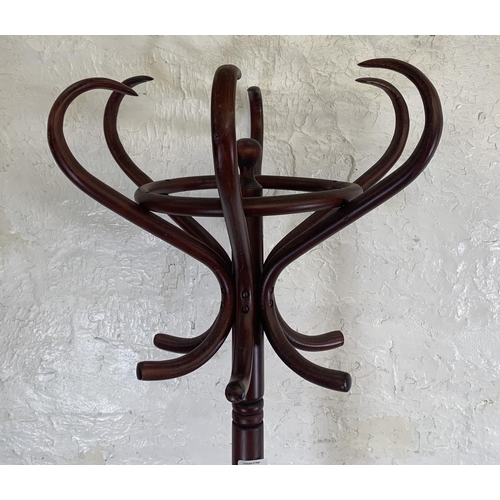 29 - A stained beech and bentwood coat stand - approx. 194cm high