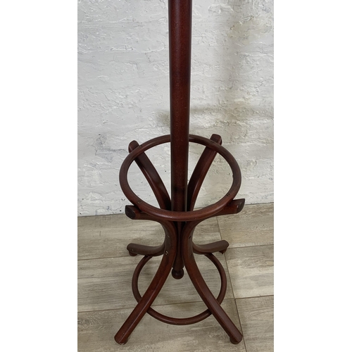 29 - A stained beech and bentwood coat stand - approx. 194cm high